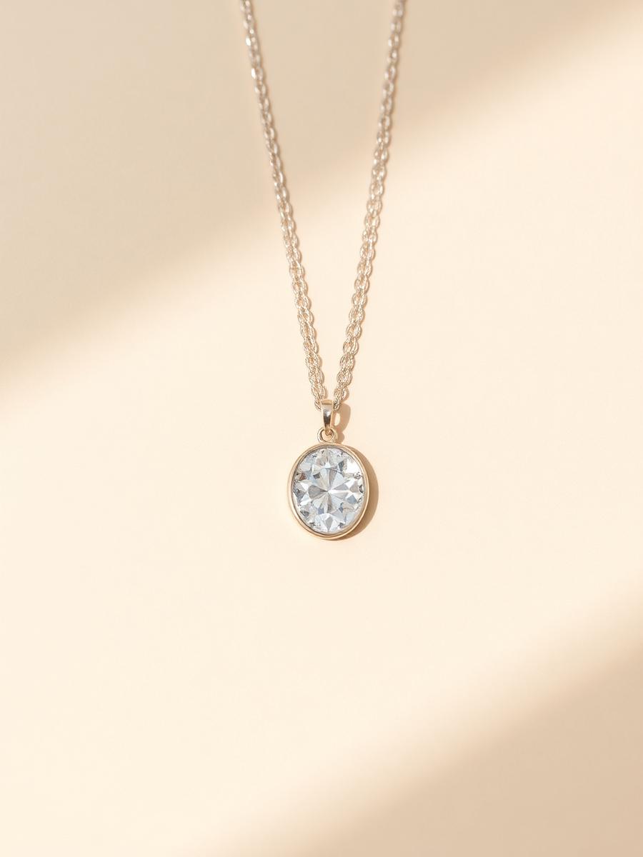 Fine chain necklace with a solitaire pendant on an ivory backdrop
